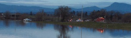 Emergency personnel assist driver stranded in the floodwaters of Sanford Road near Irwin Creek and the Laguna de Santa Rosa.